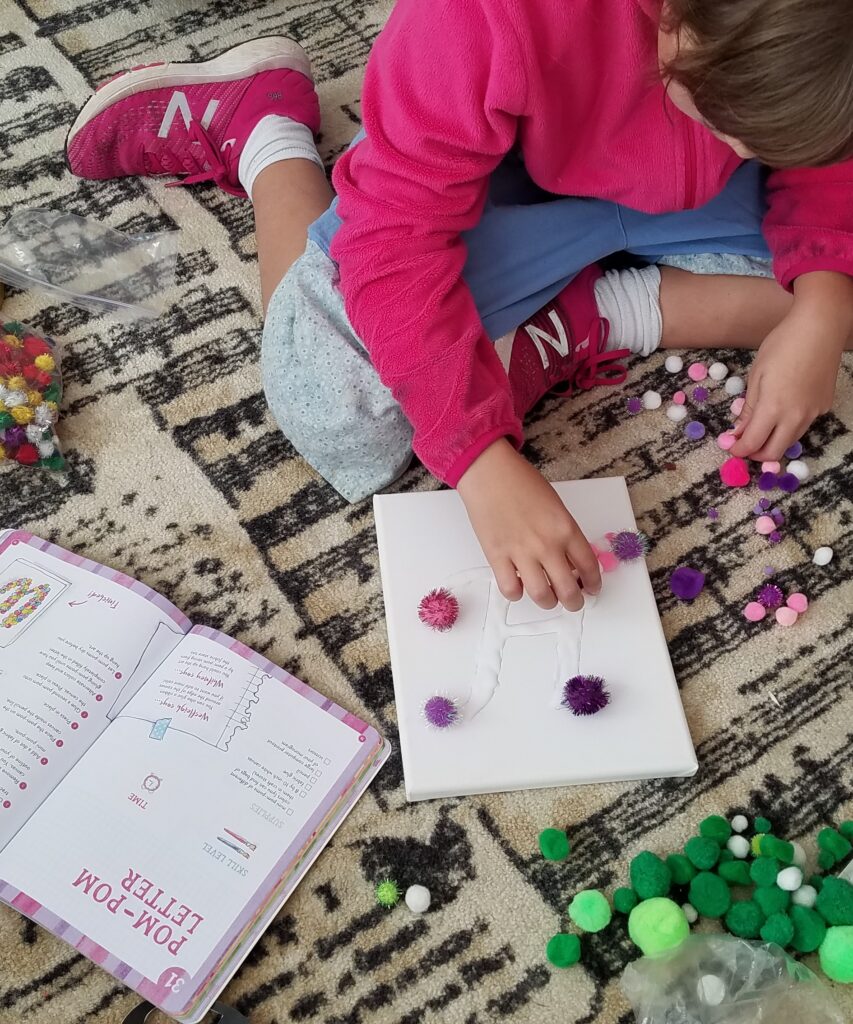 gluing pompoms on canvas craft