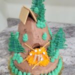 Colorful outdoor themed cake with trees, a tent, and campfire