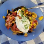 salsa in a bowl with sour cream and a spoon