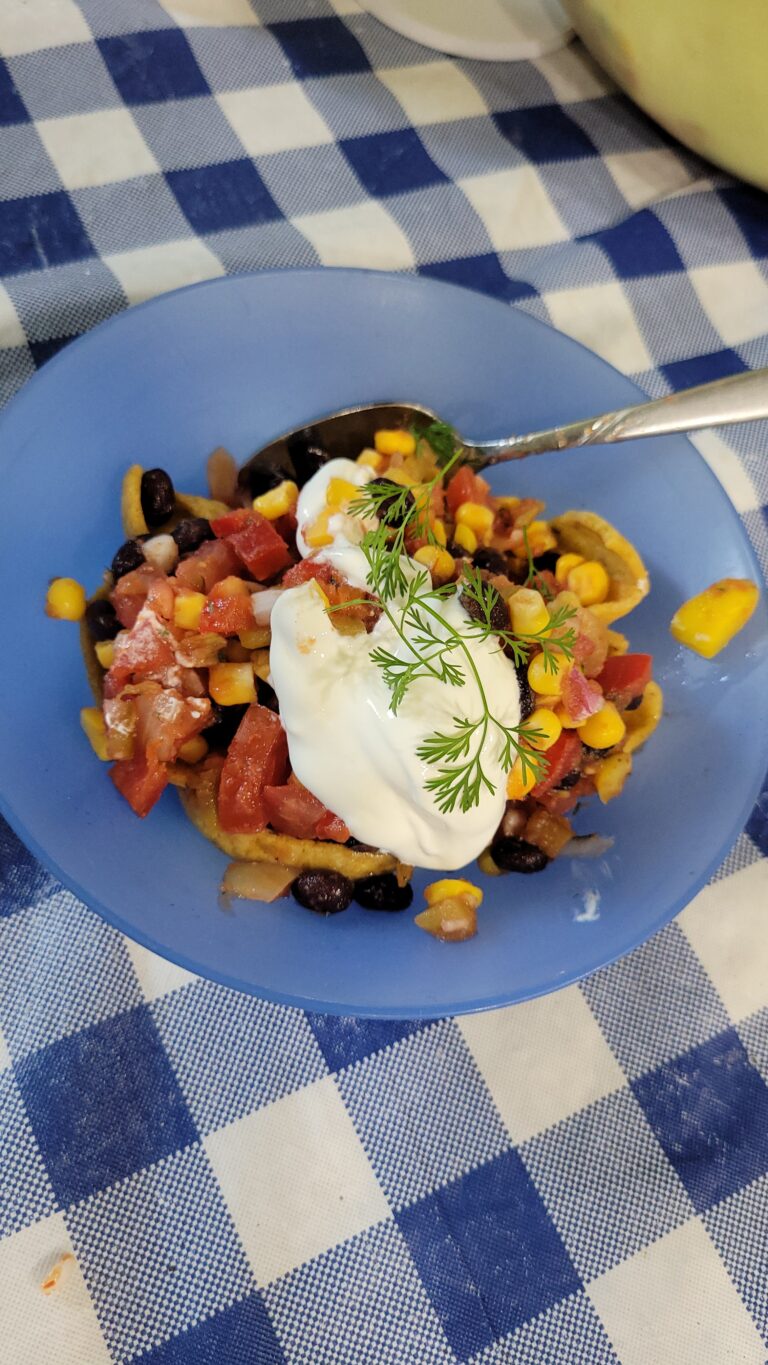 salsa in a bowl with sour cream and a spoon