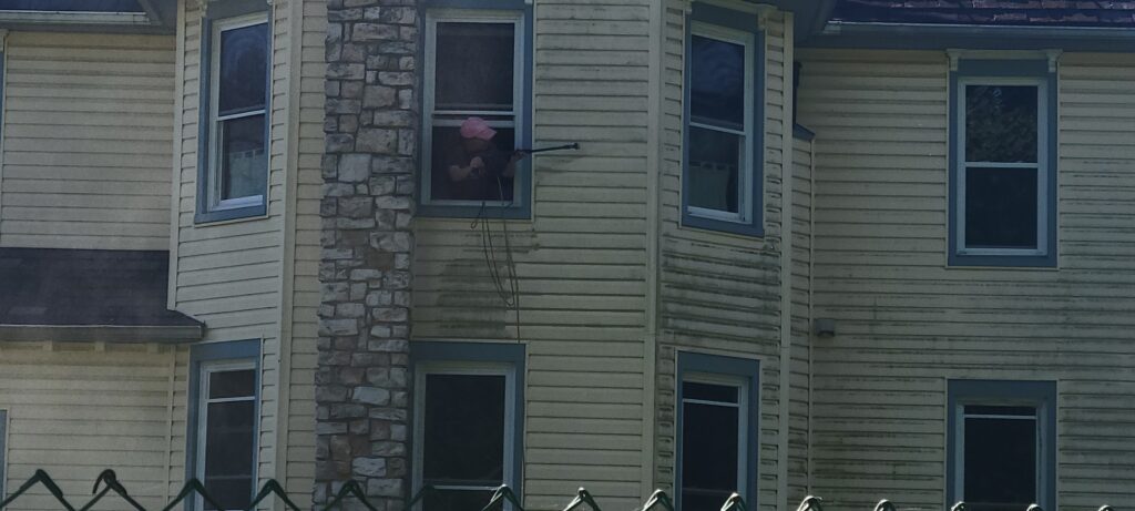 pressure washing back of house through a second story window
